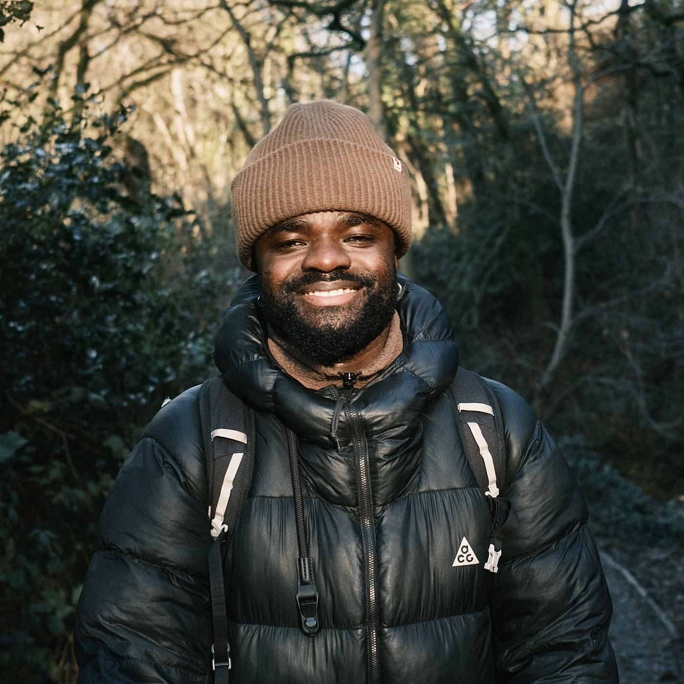 Ransford Anthony-Walker, smiling in a beanie and puffer jacket on a woodland path