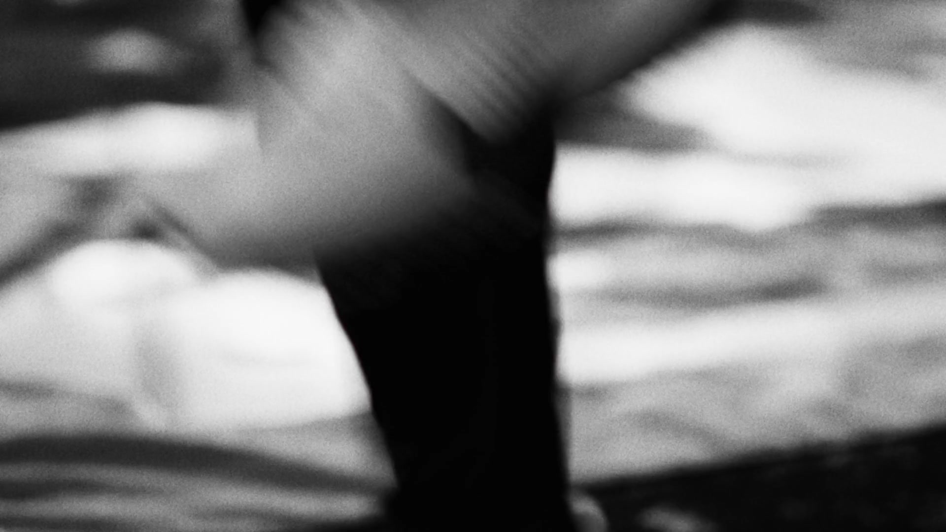 Black and white film still of a face in close-up, mid-breath
